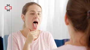 Woman checking her tongue in mirror for signs of health issues and tongue color changes